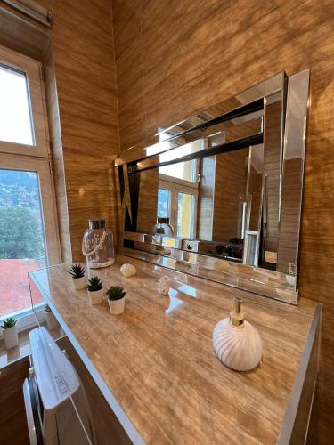 a bathroom with a counter with a large mirror at Apartment Leyla in Sarajevo