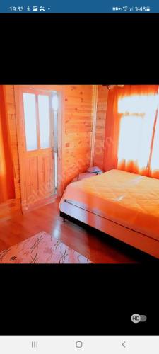 an orange bed in a room with a window at Denize 300 mt Çamlık icinde Bahçeli Müstakil Ev in Canakkale