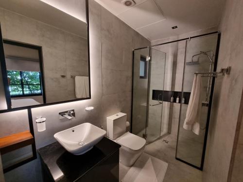 a bathroom with a sink and a toilet and a shower at VAUX PARK STREET Extended Stay Suites & Apartments in Central Colombo in Colombo