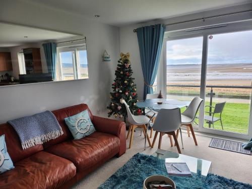 a living room with a christmas tree and a couch at Sea view apartment at the beach! in Llanelli