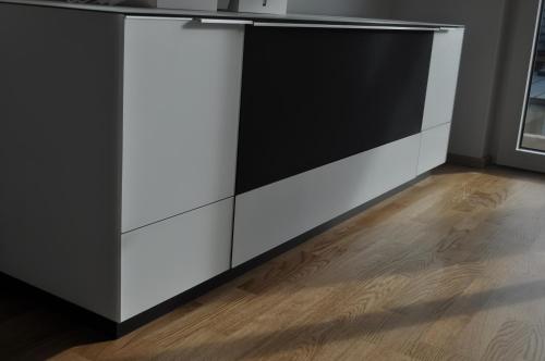 a white kitchen island with a black counter top at Sonnige Neubauwohnung - Gratwein in Kugelberg