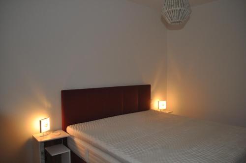 a bedroom with a bed with two lights on it at Sonnige Neubauwohnung - Gratwein in Kugelberg