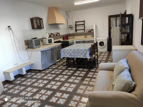 uma cozinha com um sofá e uma mesa num quarto em Cortijo Ferre, a los pies del castillo la Atalaya de Nijar em Níjar