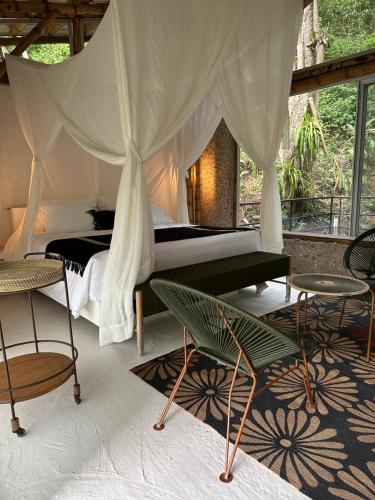 a bedroom with a bed and some chairs and tables at Selva Serena in Anapoima