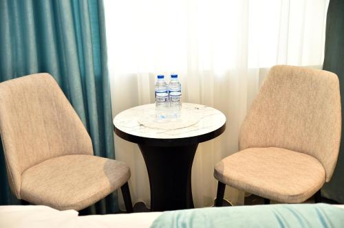 two chairs and a table with two water bottles on it at Karat Inn Boutique Hotel in Baku