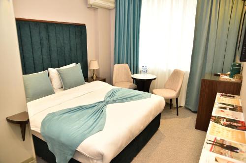 a hotel room with a bed and a table and chairs at Karat Inn Boutique Hotel in Baku