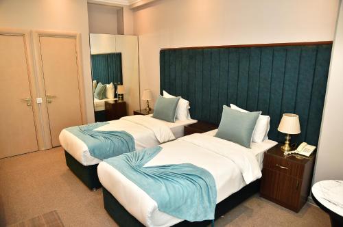 a hotel room with two beds with blue pillows at Karat Inn Boutique Hotel in Baku