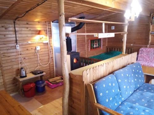una habitación con sofá y estufa en una cabaña en Domek Górski z sauną, en Laliki