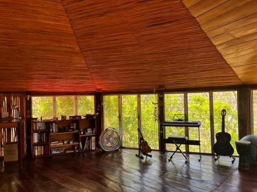 a living room with a large wooden ceiling with windows at Jungle Farm, Digital Detox Cottage in Nicaragua in La Esperanza