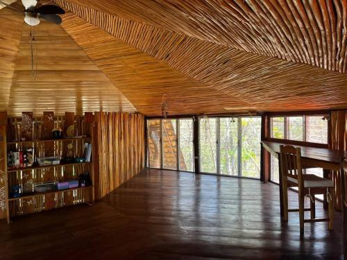 a room with a wooden ceiling and a table and chairs at Jungle Farm, Digital Detox Cottage in Nicaragua in La Esperanza