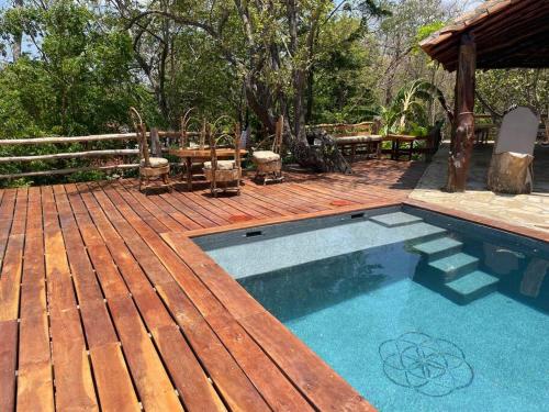 eine Holzterrasse mit Swimmingpool und einer Holzterrasse in der Unterkunft Jungle Farm, Digital Detox Cottage in Nicaragua in La Esperanza