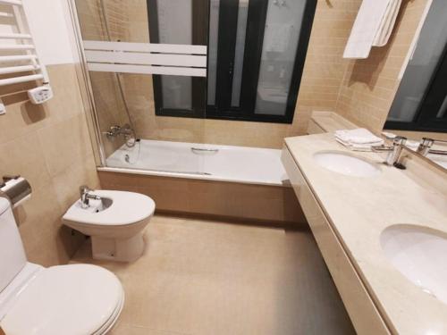 a bathroom with a toilet and a sink and a tub at Private Apartment & Pool - El Oasis Golf Resort - Fuente del Alamo in Murcia