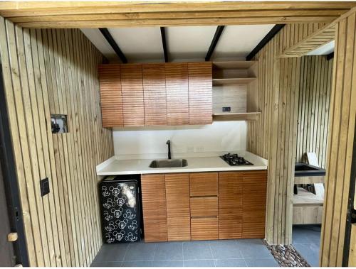 a kitchen with wooden cabinets and a sink at El paisaje mas Soñado 2 in El Retiro
