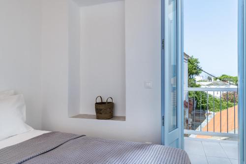 a bedroom with a bed and an open door at Villa Strada in Skopelos Town