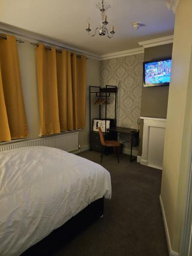 a bedroom with a bed and a desk and a television at The Market Hotel in Alton