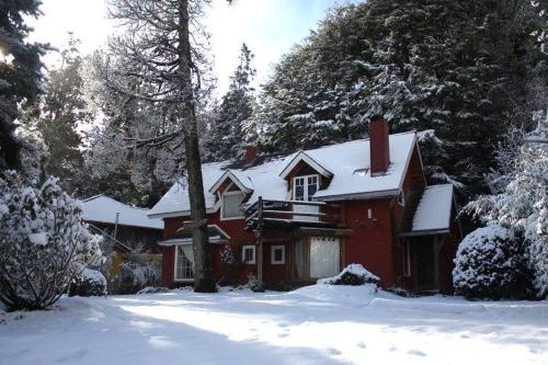 czerwony dom ze śniegiem na dachu w obiekcie Luna Roja Llao Llao w mieście Bariloche