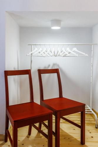 two wooden chairs in a room with a light fixture at Villa Strada in Skopelos Town