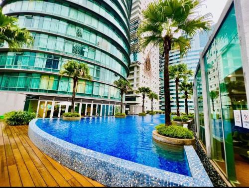 un gran edificio con una piscina frente a él con palmeras en vortex suites klcc HOLIDAY apartment en Kuala Lumpur