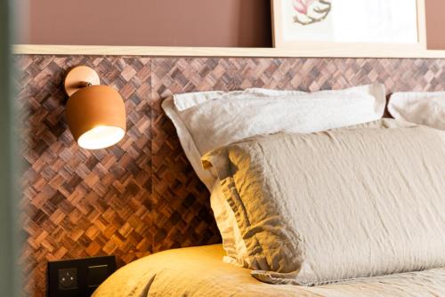 a bedroom with a bed with a headboard and a lamp at Serra Boutique Hôtel in Agen