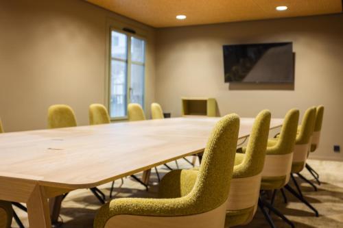 a conference room with a wooden table and chairs at Serra Boutique Hôtel in Agen
