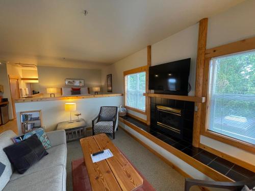 a living room with a couch and a flat screen tv at BOATYARRD Inn # 9 in Langley