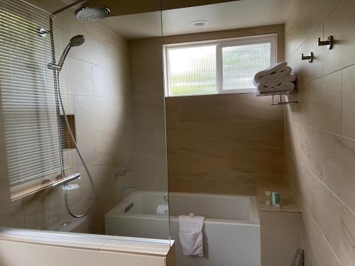 a bathroom with a shower and a tub and a sink at BOATYARRD Inn # 9 in Langley