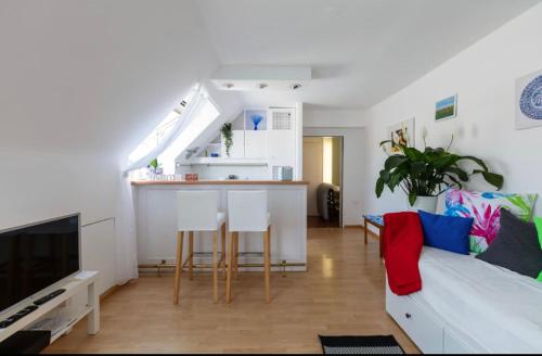 ein Wohnzimmer mit einem Sofa und eine Küche mit einer Theke in der Unterkunft roof top studio in Wien