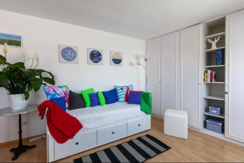 ein Wohnzimmer mit einer weißen Couch mit bunten Kissen in der Unterkunft roof top studio in Wien