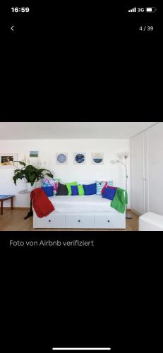 ein weißes Sofa mit bunten Kissen in einem Zimmer in der Unterkunft roof top studio in Wien