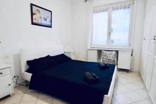 ein Schlafzimmer mit einem blauen Bett und einem Fenster in der Unterkunft [Garda Lake]-Raffinato appartamento in Toscolano-Maderno