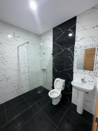 a bathroom with a toilet and a sink at Résidence Amina B in Al Hoceïma