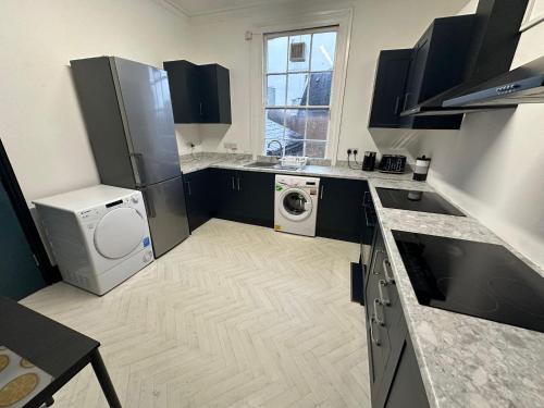 a kitchen with a washer and dryer in it at 10 Minutes to Central London Vaux in London