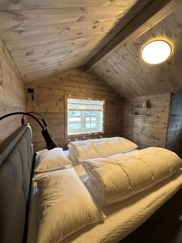 a bedroom with two beds in a log cabin at Holiday cottage with sauna close to Kjeragbolten-Bedding included in Tjørhom