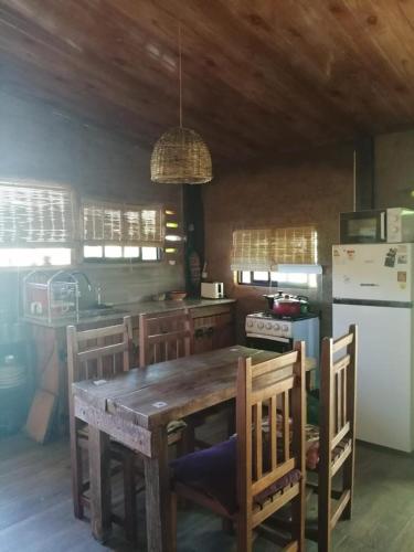 a kitchen with a wooden table with chairs and a refrigerator at Calma in Cuchilla Alta