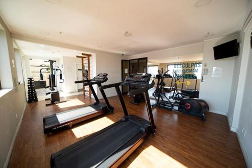 a gym with several treadmills and machines in a room at Atlântica Hotel 5 estrelas - Coração da Faria Lima in Sao Paulo