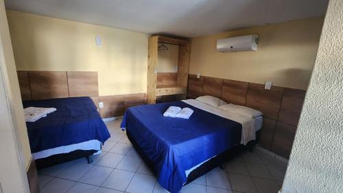 two beds in a room with blue sheets and towels at Pousada Ceará - Porto das Dunas in Aquiraz