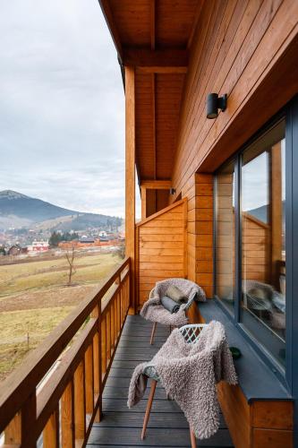 a porch of a cabin with two chairs and a window at Yo Hotel in Bukovel