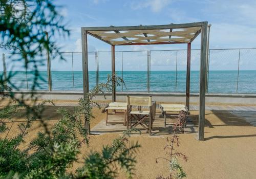 a gazebo with two chairs and a table on the beach at Il Delfinetto in San Vincenzo