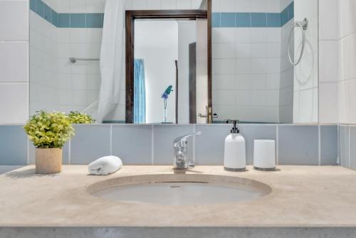 een badkamer met een wastafel en een spiegel bij Apartamento São João in Funchal
