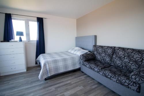 a living room with a couch and a bed at Motel de la mer in Rimouski