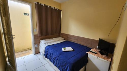 a small bedroom with a bed and a television at Pousada Ceará - Porto das Dunas in Aquiraz