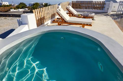 a small swimming pool with a table and chairs at Athiri Santorini Hotel in Imerovigli