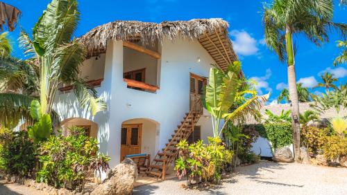ein Haus am Strand mit Palmen in der Unterkunft Paradiso del Caribe in Las Galeras