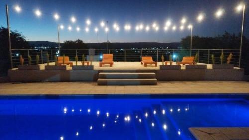 - une terrasse avec des chaises et une piscine la nuit dans l'établissement Cabañas Nakupenda, à Villa Carlos Paz