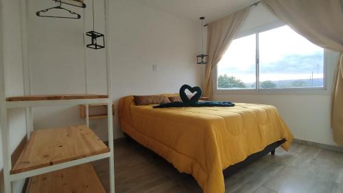 Un dormitorio con una cama con un corazón negro. en Cabañas Nakupenda en Villa Carlos Paz
