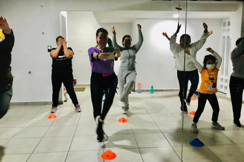a group of people dancing in a room at familia fitness in San Roque