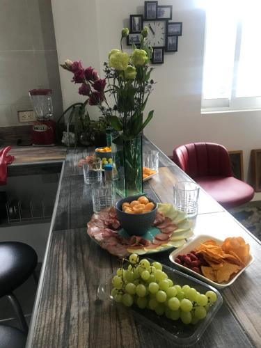 a table with a plate of fruit and a vase of flowers at familia fitness in San Roque
