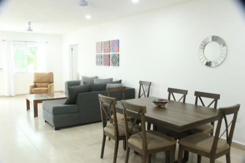 ein Wohnzimmer mit einem Sofa, einem Tisch und Stühlen in der Unterkunft Edifico con departamentos amplios cerca de la playa in Puerto Morelos