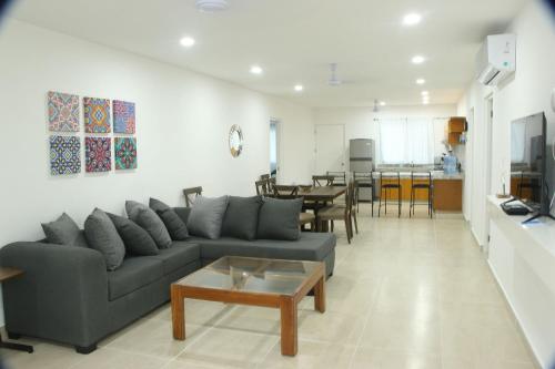 salon z kanapą i stołem w obiekcie Edifico con departamentos amplios cerca de la playa w mieście Puerto Morelos