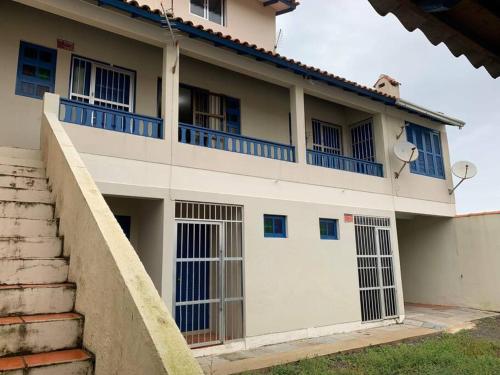 ein weißes Gebäude mit blauen Fenstern und einem Balkon in der Unterkunft Apartamento de 6a8 P Churrasqueira in Cidreira